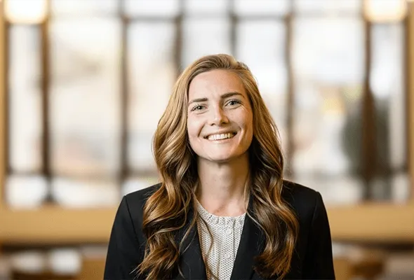 A female student smiles at the camera, representing a leader